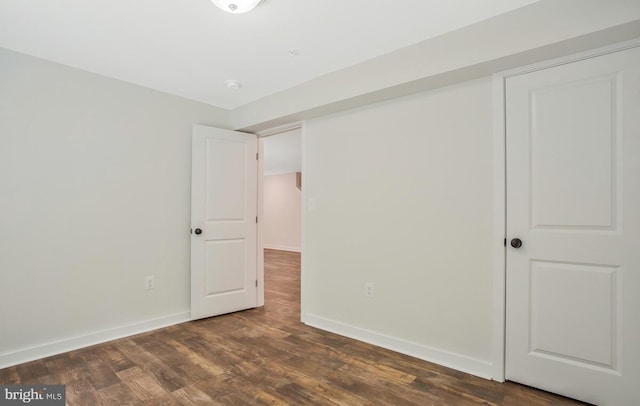 unfurnished bedroom with dark wood finished floors and baseboards