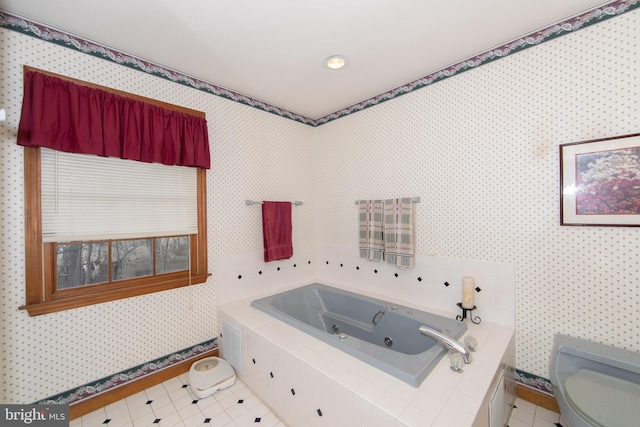 bathroom featuring a relaxing tiled tub, tile patterned floors, and toilet