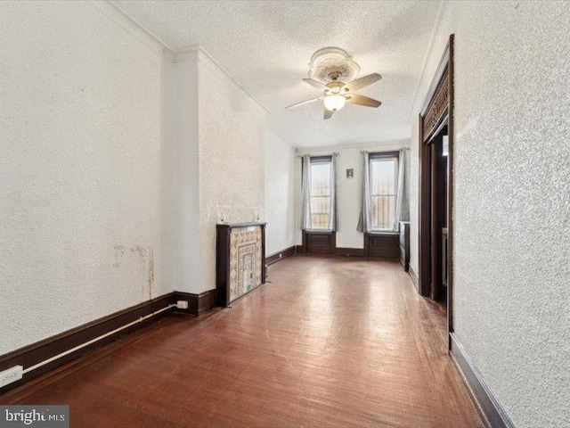 corridor featuring crown molding, dark wood-type flooring, and a textured ceiling