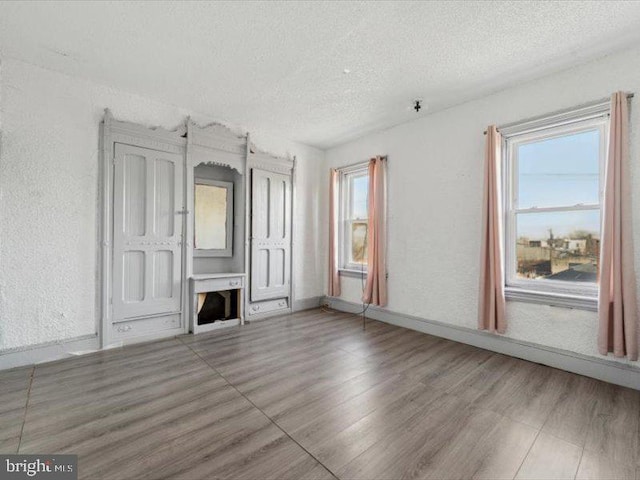 unfurnished living room featuring a textured ceiling and hardwood / wood-style flooring