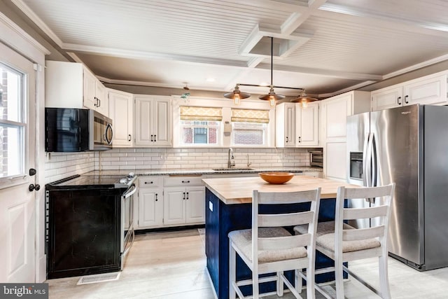 kitchen with white cabinets, wooden counters, and appliances with stainless steel finishes