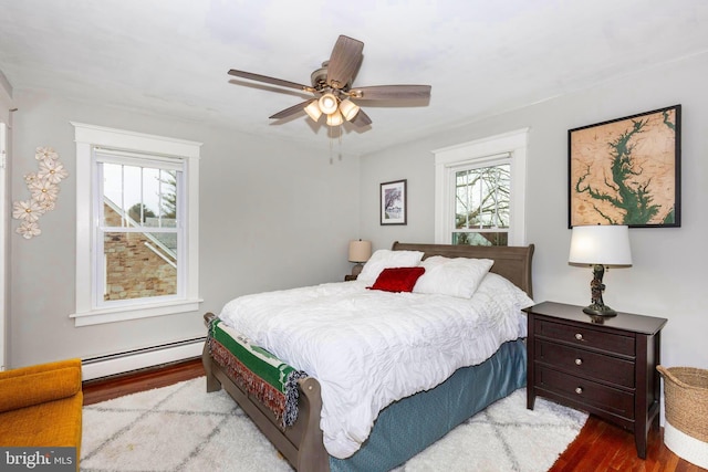 bedroom with multiple windows, a baseboard radiator, light hardwood / wood-style flooring, and ceiling fan