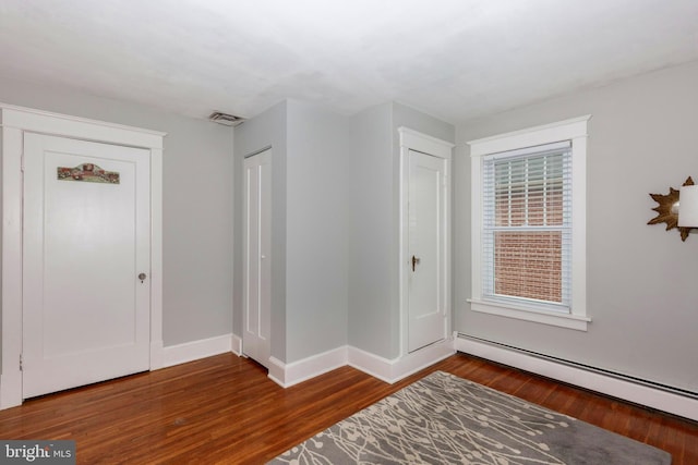 entrance foyer featuring dark hardwood / wood-style flooring and a baseboard radiator