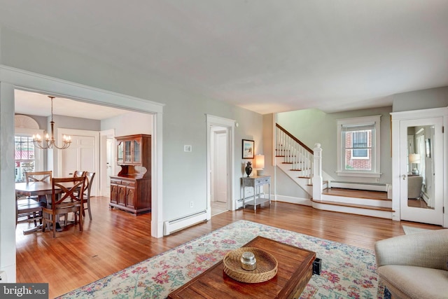 living room featuring a chandelier, wood-type flooring, and a baseboard radiator