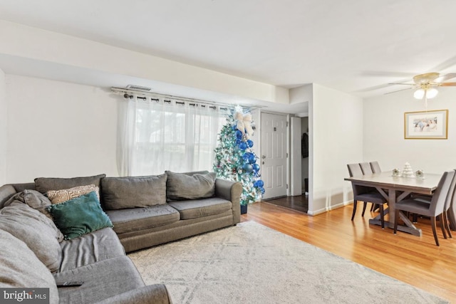 living room with ceiling fan and wood-type flooring