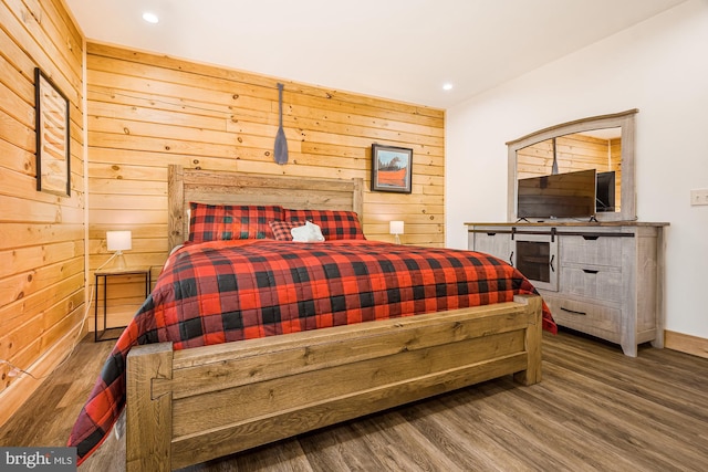 bedroom with wood walls and wood-type flooring