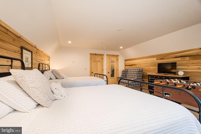 bedroom with wooden walls and vaulted ceiling