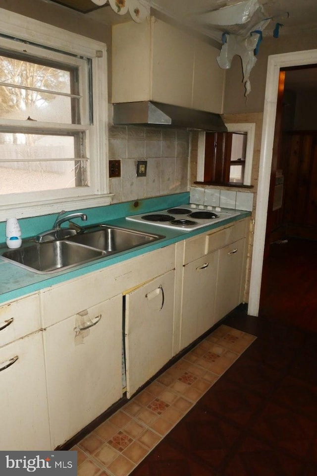 kitchen with decorative backsplash, white electric cooktop, white cabinetry, and sink