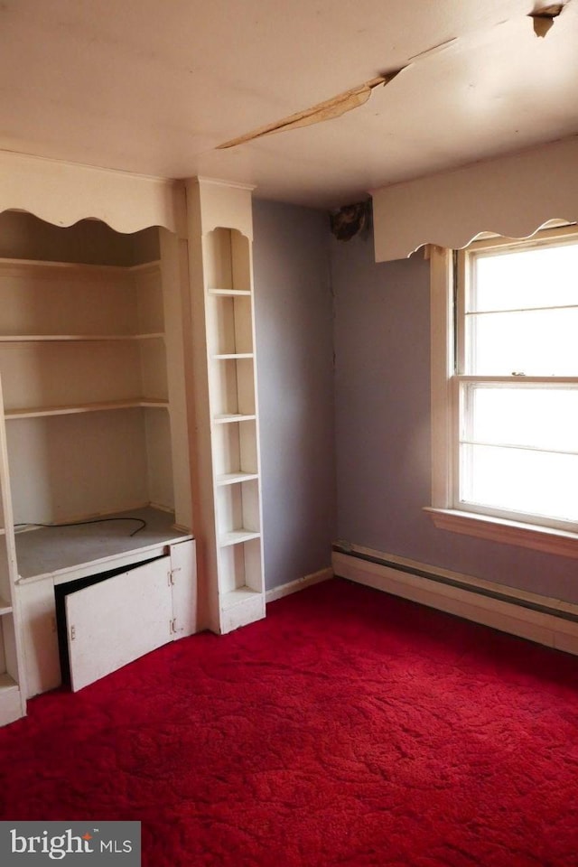 interior space with carpet flooring and a baseboard heating unit