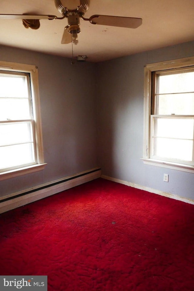 carpeted empty room with ceiling fan and a baseboard radiator