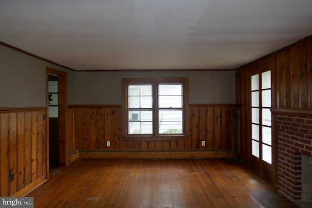 unfurnished room featuring dark hardwood / wood-style floors, a fireplace, and wooden walls