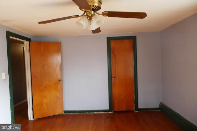 empty room with ceiling fan and dark wood-type flooring