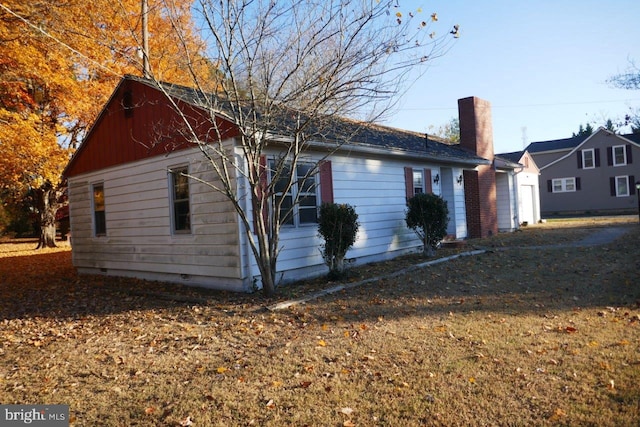 view of side of home featuring a lawn and a garage