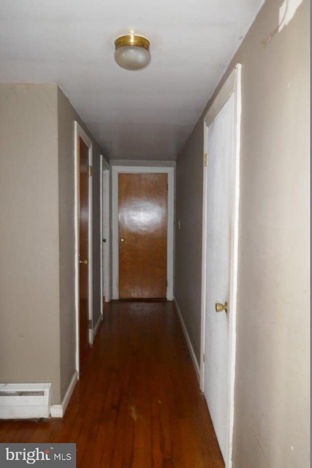 hallway featuring dark hardwood / wood-style flooring and a baseboard heating unit