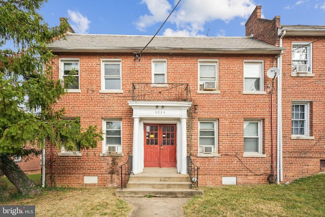 view of front facade with cooling unit and a front lawn