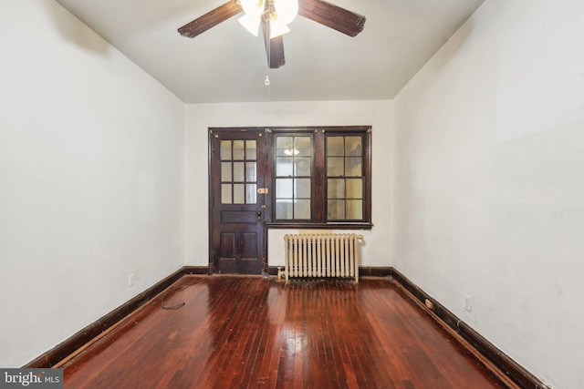 empty room featuring radiator heating unit, hardwood / wood-style flooring, and ceiling fan