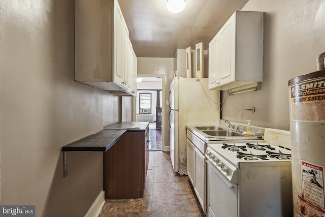 kitchen featuring white cabinets, white appliances, dark tile patterned floors, and sink