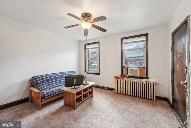 living area featuring carpet flooring, radiator heating unit, ceiling fan, and cooling unit