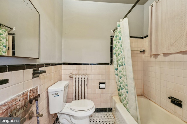 bathroom with radiator heating unit, shower / bath combo, tile walls, and toilet