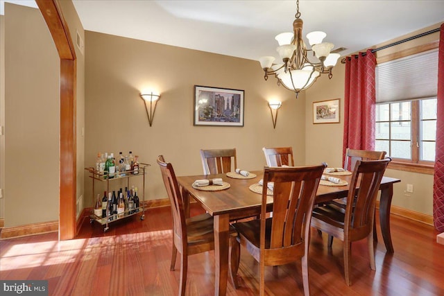 dining area featuring an inviting chandelier and hardwood / wood-style flooring