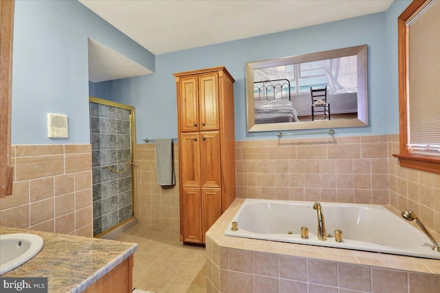 bathroom with tile patterned flooring, tile walls, vanity, and shower with separate bathtub