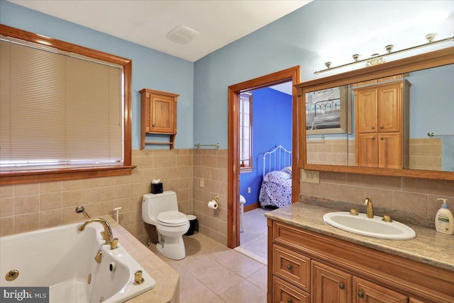 bathroom featuring a relaxing tiled tub, tile patterned floors, vanity, and toilet