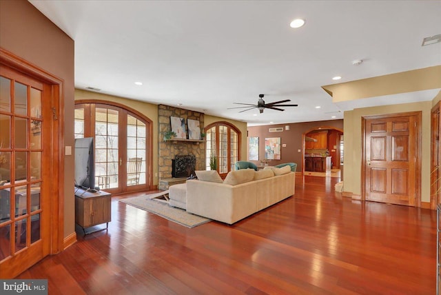 living room with ceiling fan, hardwood / wood-style floors, a fireplace, and french doors