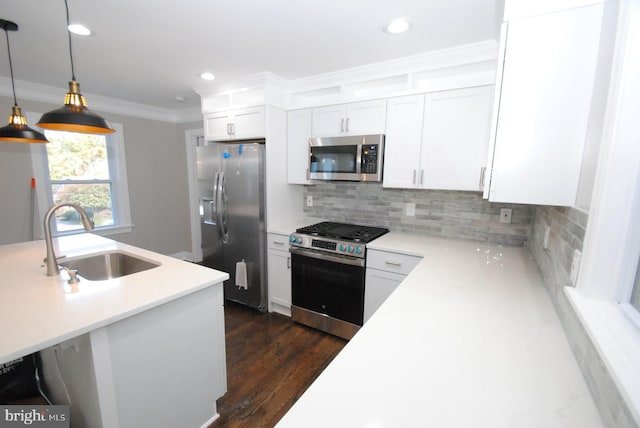 kitchen featuring white cabinetry, sink, hanging light fixtures, dark wood-type flooring, and stainless steel appliances