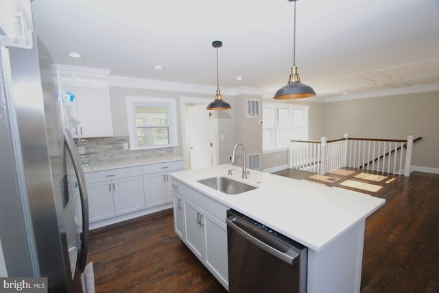 kitchen featuring white cabinetry, sink, an island with sink, pendant lighting, and appliances with stainless steel finishes