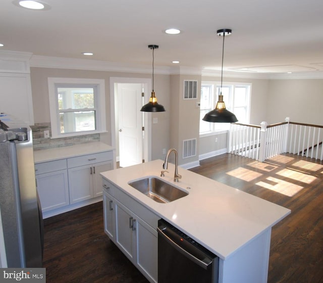 kitchen featuring dishwasher, a kitchen island with sink, sink, decorative light fixtures, and white cabinetry