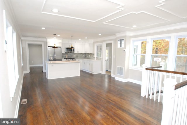 kitchen featuring dark hardwood / wood-style flooring, stainless steel appliances, white cabinetry, and an island with sink