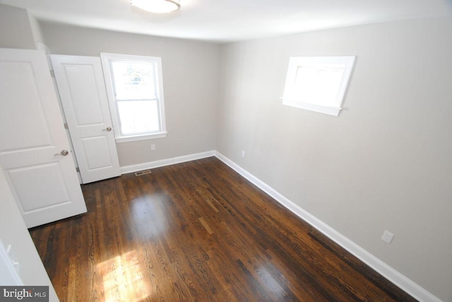 empty room with dark hardwood / wood-style flooring