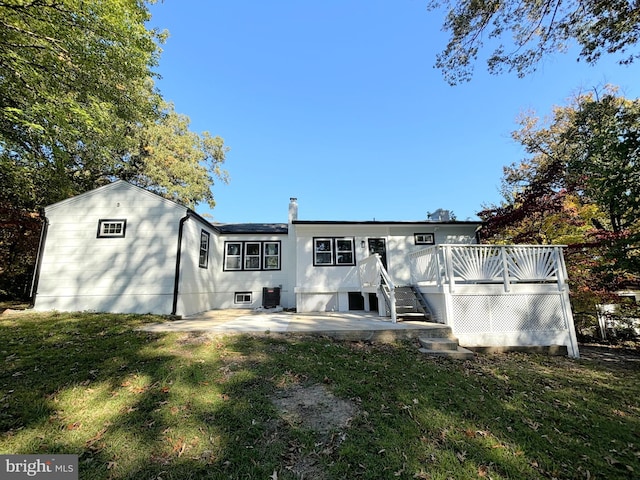 back of house with a lawn, a wooden deck, a patio, and central AC