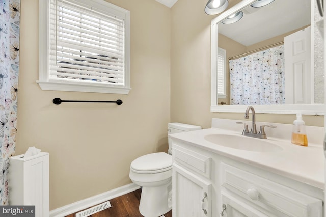 bathroom with vanity, hardwood / wood-style flooring, toilet, and a wealth of natural light