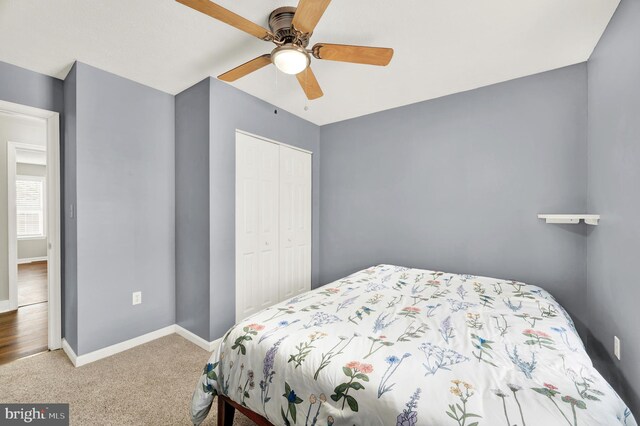 carpeted bedroom with ceiling fan and a closet