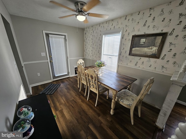 dining space featuring ceiling fan, dark wood-type flooring, and a textured ceiling