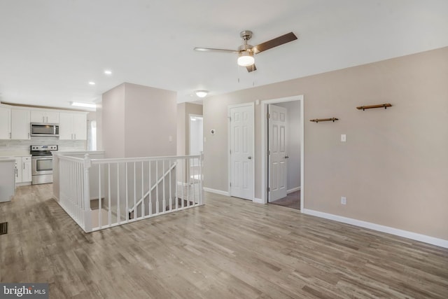 unfurnished room with ceiling fan and light hardwood / wood-style flooring