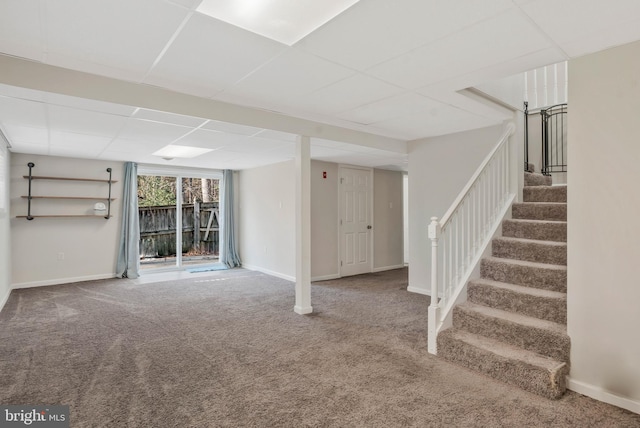 basement featuring a paneled ceiling and carpet floors