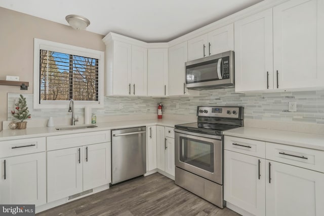 kitchen featuring white cabinetry, sink, stainless steel appliances, and dark hardwood / wood-style floors