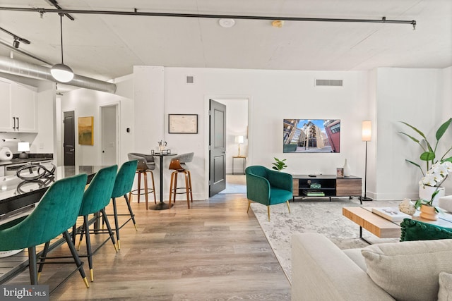living room with visible vents and light wood-type flooring