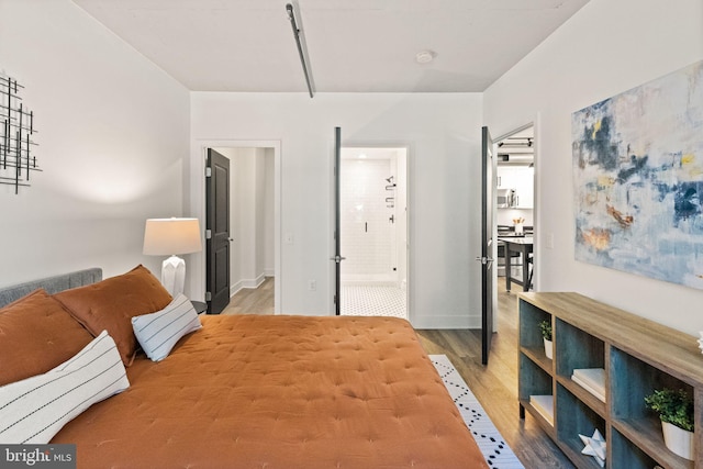 bedroom featuring baseboards and wood finished floors