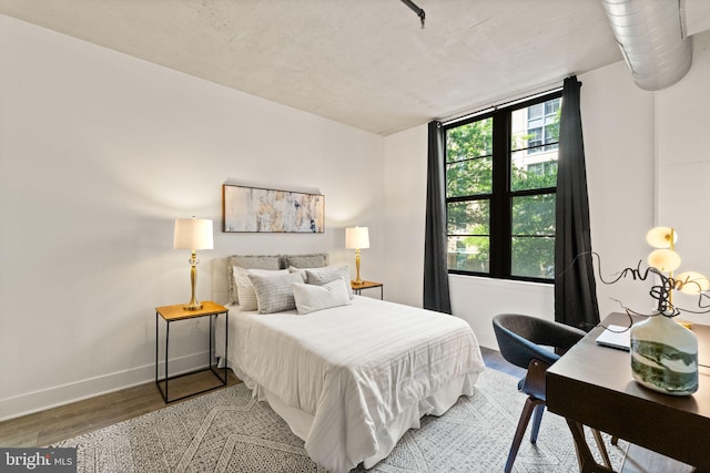 bedroom featuring baseboards and wood finished floors