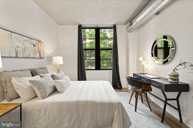 bedroom featuring baseboards and wood finished floors