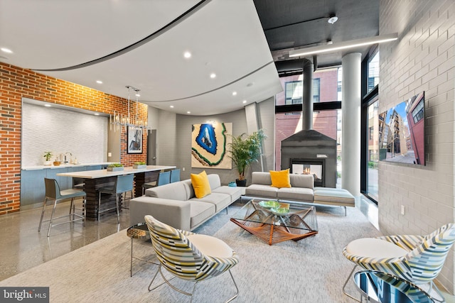 living room featuring recessed lighting and brick wall