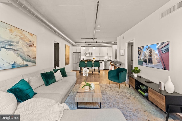 living area featuring visible vents and light wood finished floors