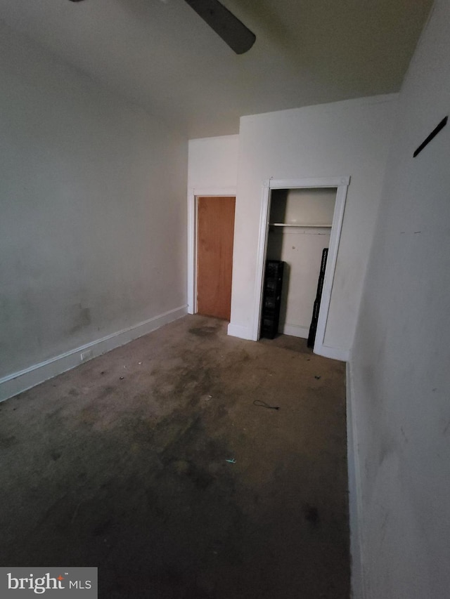 unfurnished bedroom featuring ceiling fan and a closet