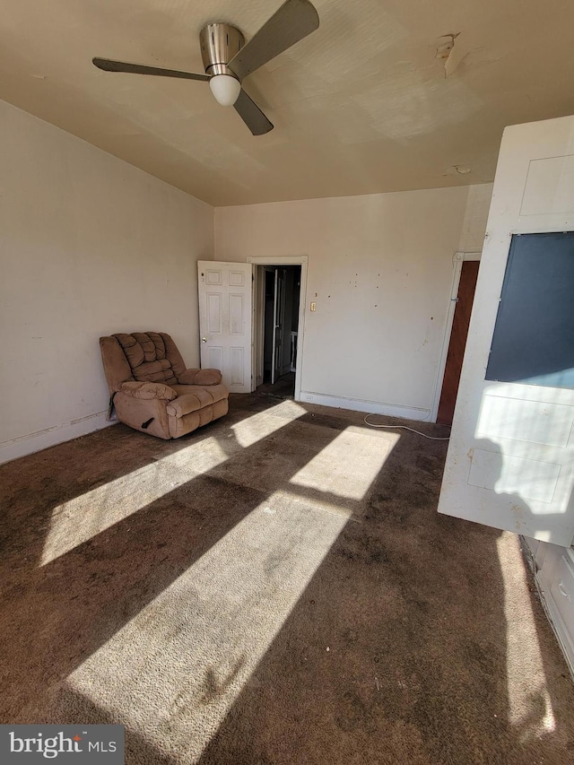 unfurnished living room featuring dark colored carpet and ceiling fan