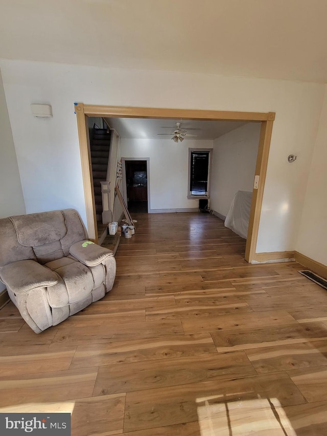 unfurnished living room featuring ceiling fan and hardwood / wood-style floors