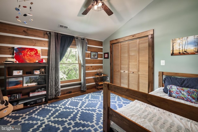bedroom featuring lofted ceiling, wood finished floors, ceiling fan, and a closet