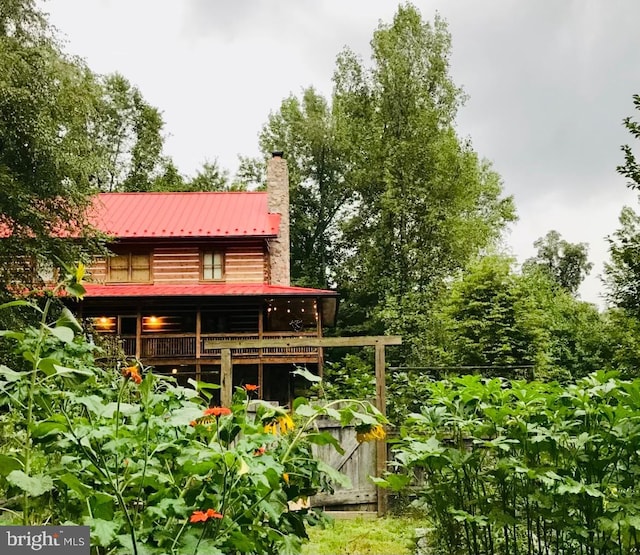back of property with a chimney and metal roof